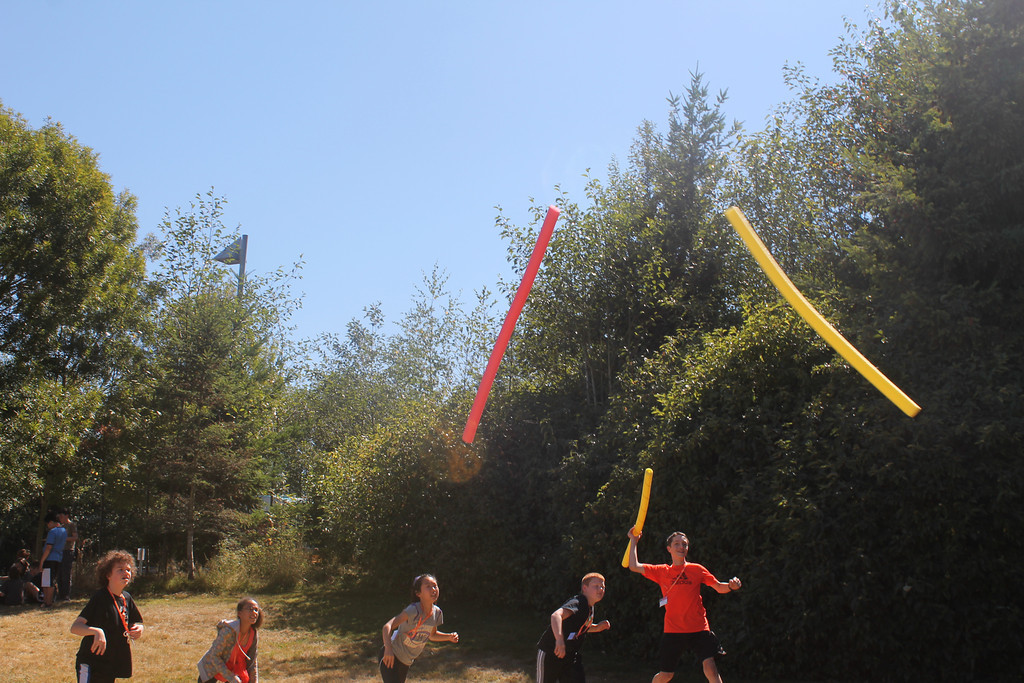 students playing with pool noodles
